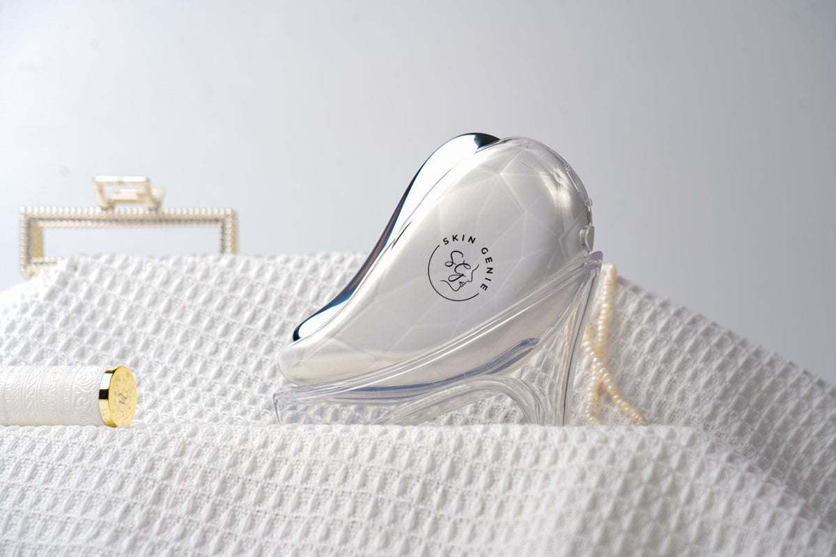 La Beauté electric gua sha resting on a folded white towel