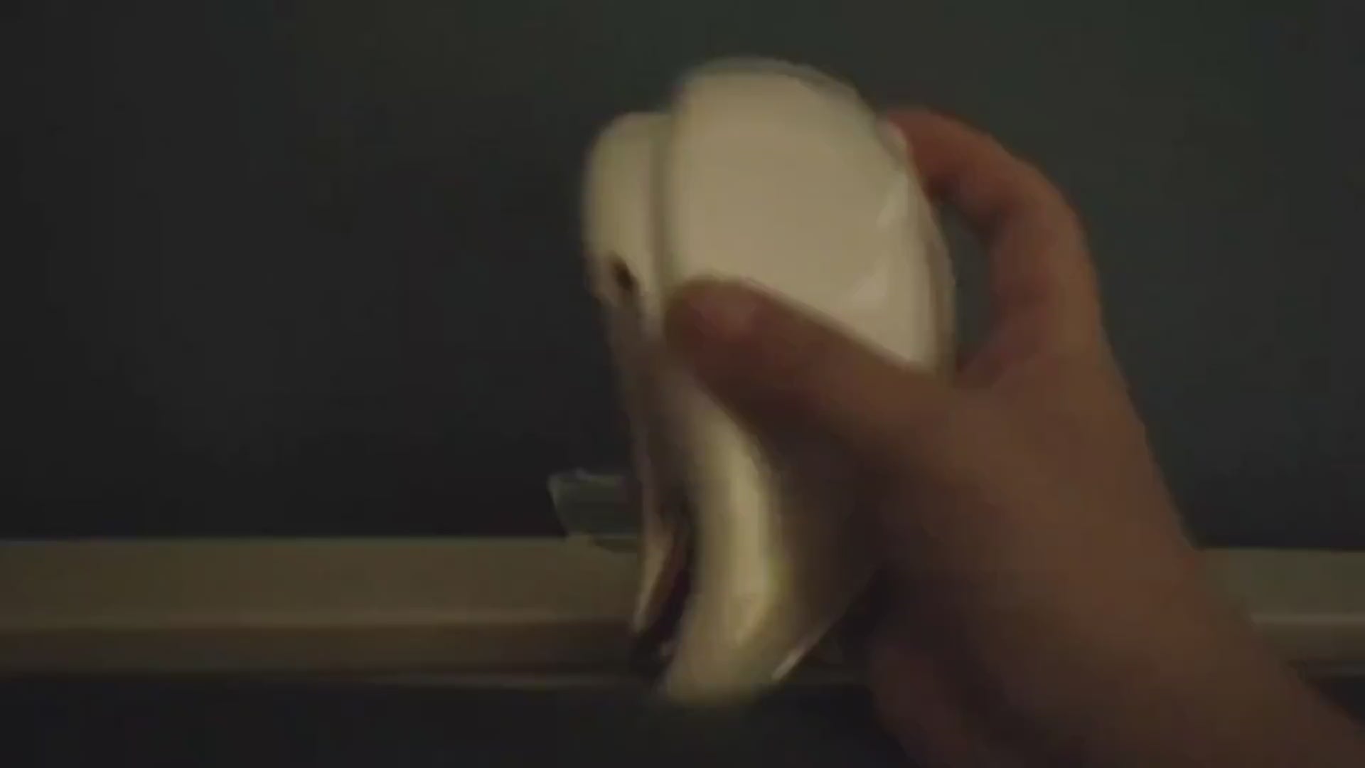 The electric gua sha cycling through its warm, cool, and light modes in a dark room