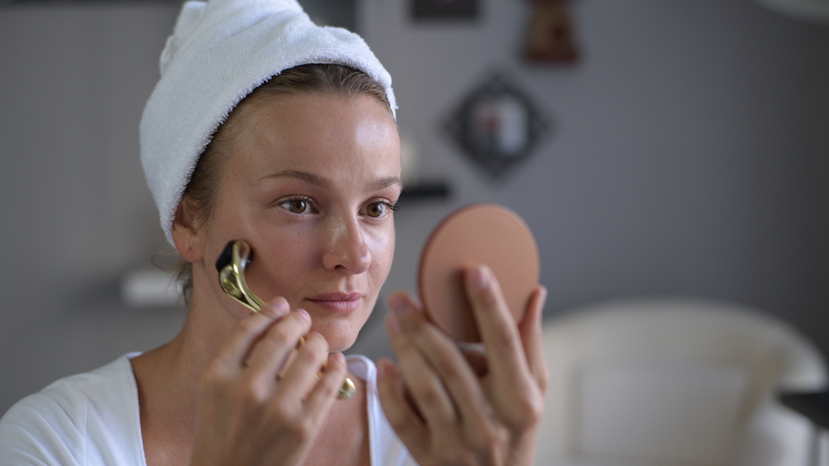 The gold roller moving across the cheekbone, light pressure